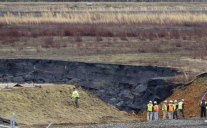  In a Wednesday, Feb. 5, 2014 file photo, Duke Energy engineers and contractors survey the site of a coal ash spill at the Dan River Power Plant in Eden, N.C., as state and federal environmental officials continued their investigations of the spill into the river. 