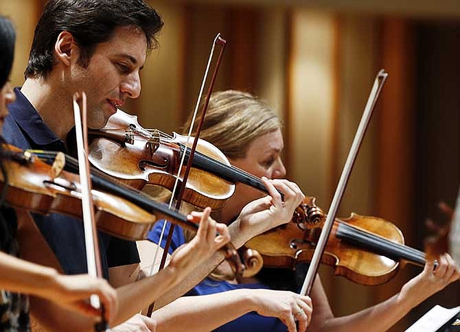 In this Thursday, March, 27, 2014 photo, three Stradivarius violins are seen, from left, South Korean Chee-Yun, plays the 1714 "Leonora Jackson," Russian-American Philippe Quint plays the 1708 "Ruby," middle and Margaret Batjer, concertmaster of the Los Angeles Chamber Orchestra, right, plays the the 1716 "Milstein" during a rehearsal at the Colburn School in Los Angeles. 