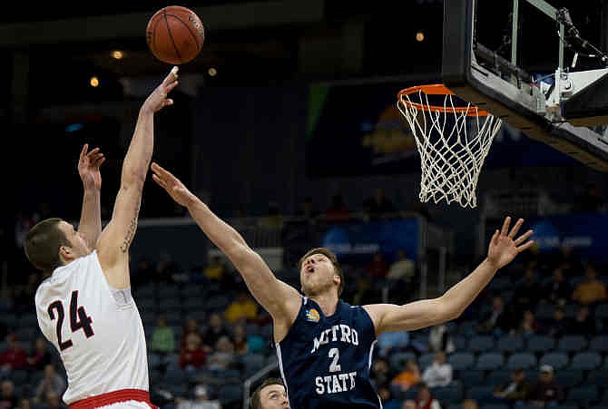 Central Missouri's Dillon Deck (24) shoots over Metro State's Will Sinclair (2) during their game at the 2014 NCAA Division II National Semifinals at the Ford Center in Evansville Thursday night, March 27, 2014. The 20th-ranked Central Missouri Mules knocked off the number one-ranked Metro State Roadrunners 69-71. 