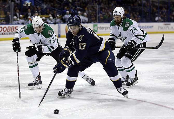 St. Louis Blues' Vladimir Sobotka, of the Czech Republic, reaches for the puck as Dallas Stars' Valeri Nichushkin, left, of Russia, and Jordie Benn, right, give chase during the second period of an NHL hockey game Saturday, March 29, 2014, in St. Louis. 
