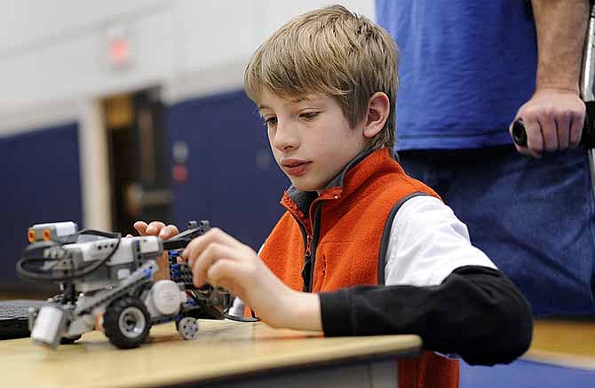 Under the watchful eye of his dad Patrick Ashley, right, Cameron Ashley makes adjustments to his tractorbot while participating in the RoboFest competition at Lincoln University's Jason Gym.