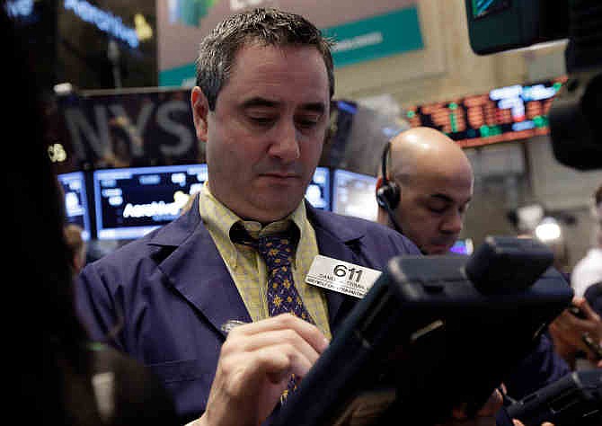  In this Friday, March 28, 2014, file photo, Trader Daniel Trimble, left, works on the floor of the New York Stock Exchange. 