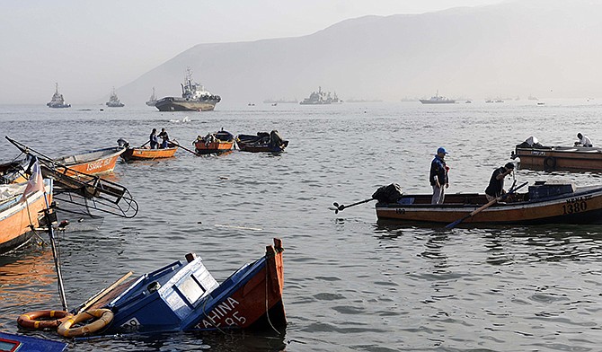 Fishing boats lie damaged by a small tsunami in the northern town of Iquique, Chile, after magnitude 8.2 earthquake struck the northern coast of Chile on Tuesday. 