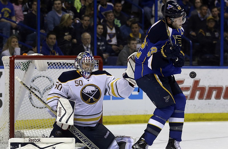 The Blues' David Backes gets hit by a puck as Sabres goalie Nathan Lieuwen looks on during the second period of Thursday's game in St. Louis.