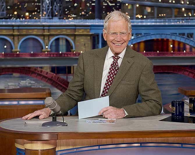 In this photo provided by CBS, David Letterman, host of the "Late Show with David Letterman," is seated at his desk in New York on Thursday, April 3, 2014. During taping of the Thursday night telecast, Letterman announced that he will retire in 2015 when his contract expires. He announced no specific end date, telling his audience he expects his exit will be in "at least a year or so, but sometime in the not too distant future, 2015, for the love of God, (band leader) Paul (Shaffer) and I will be wrapping things up." 