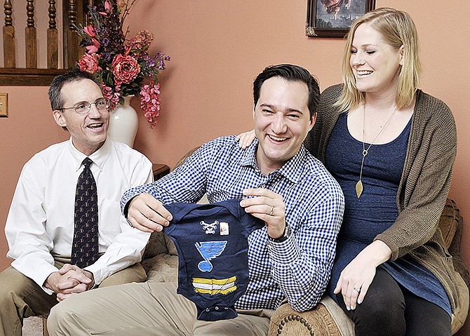 Lucas Schwaller opens a gift for his and wife Courtney Schwaller's first child. It's a Blues hockey onesie courtesy of Brad Scroggs, at left. Scroggs served as Schwaller's big brother through the Big Brothers Big Sisters program. After 22 years as friends, the two are still involved in each others' lives.