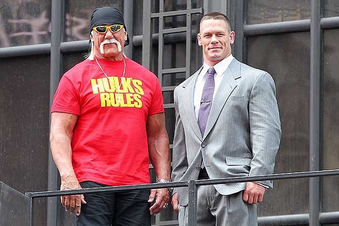 This image released by Starpix shows professional wresting personalities Hulk Hogan, left, and John Cena on top of the The Hard Rock Cafe during a news conference for Wrestlemania 30 on Tuesday, April 1, 2014 in New York. Wrestlemania 30 will be held on Sunday, April 6 in New Orleans .