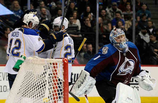 Colorado Avalanche goalie Semyon Varlamov, right, of Russia, reacts as St. Louis Blues center David Backes, left, and St. Louis Blues left wing Alexander Steen, center, celebrate a goal by Backes in the second period of an NHL hockey game on Saturday, March 8, 2014, in Denver.