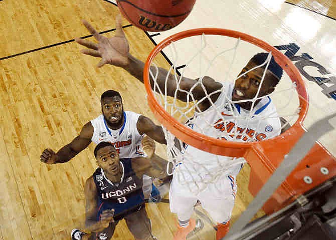 Florida forward Casey Prather shoots as Connecticut forward Phillip Nolan (0) and Florida's Patric Young (4) look on during the first half of an NCAA Final Four tournament college basketball semifinal Saturday, April 5, 2014, in Arlington, Texas.