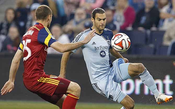 Sporting Kansas City midfielder Graham Zusi, right, plays the ball while covered by Real Salt Lake defender Rich Balchan (25) during the first half of an MLS soccer match in Kansas City, Kan., Saturday, April 5, 2014. 