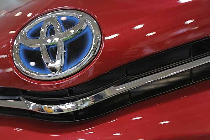 In this Aug. 2, 2013 file photo, the emblem of a Toyota car shines at Toyota Motor Corp.'s showroom Toyota Mega Web in Tokyo. 