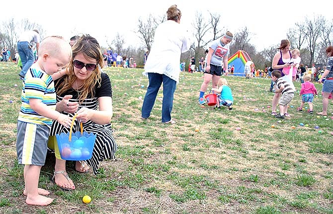 Jefferson City resident Jessica Decker assisted her son, Gavin, in finding a basket full of candy and prize filled eggs during the 1-3 age division hunt at the Eldon Egg-stravaganza Saturday.