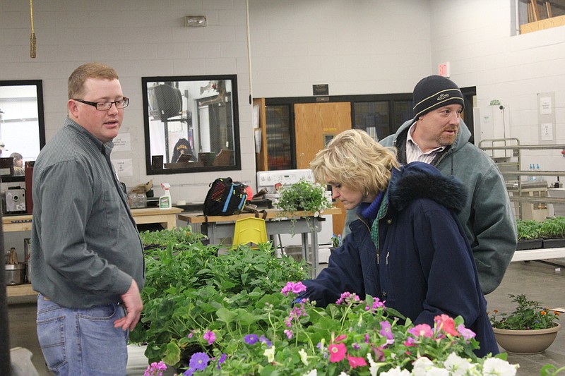 FFA Advisor James Rinck, left, helps Teresa and Tim Kucera pick out new additions to their garden during the Fulton FFA's plant sale Monday.