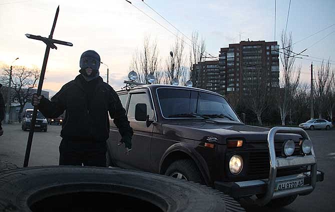 A pro-Russian resident stands at a barricade in Kramatorsk, eastern Ukraine, Tuesday, April 15, 2014. In the first Ukrainian military action against a pro-Russian uprising in the east, government forces clashed Tuesday with about 30 armed gunmen at a small airport in Kramatorsk. 