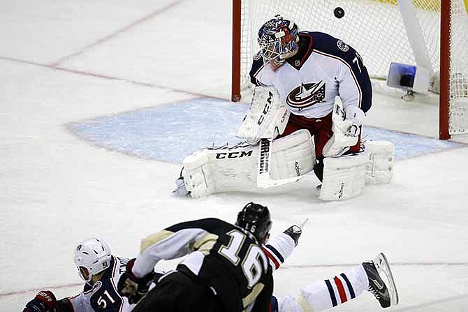 Pittsburgh Penguins' Brandon Sutter (16) puts the puck over Columbus Blue Jackets goalie Sergei Bobrovsky (72) and Fedor Tyutin (51) for a goal in the third period of a first-round NHL playoff hockey game in Pittsburgh Wednesday, April 16, 2014. The Penguins won 4-3, with Sutter's goal being the game-winner. 