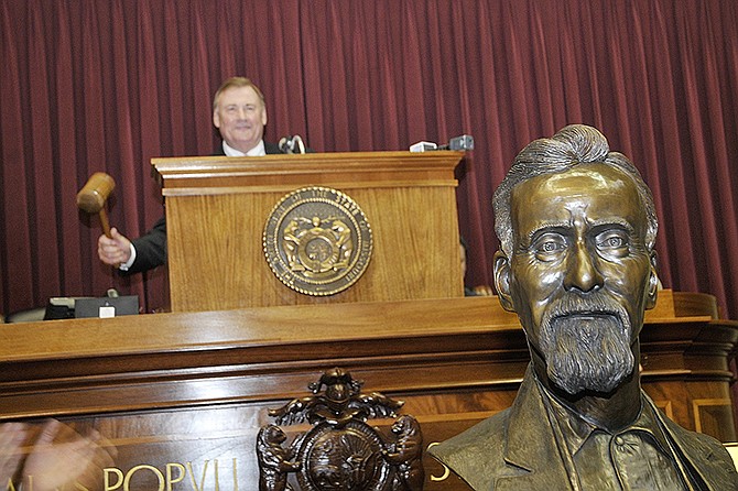 With the just unveiled bust of of Andrew T. Still in the foreground, Rep. Nate Walker, R-Kirksville, bangs the gavel to close the ceremony Wednesday in  Jefferson City. With descendents present, Andrew Still's bust was inducted into the Hall of Famous Missourians in a brief ceremony in the House of Representatives.