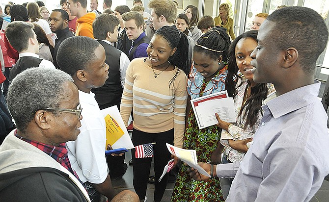 Moses Glay, left, and his son Anthony Glay, a new U.S. citizen, second from left, talk to students and answer questions about becoming a U.S. citizen. Students in Melanie Fraga's English for Speakers of Other Languages class made cards to congratulate the new citizens. From right, Charles Asare, Faith Marah, Naomi Kerkula and Merveille Kumeso welcome Moses, who was naturalized four years ago, and Anthony, who was naturalized Thursday. Students from Jefferson City High School sponsored Thursday's reception in the atrium. 