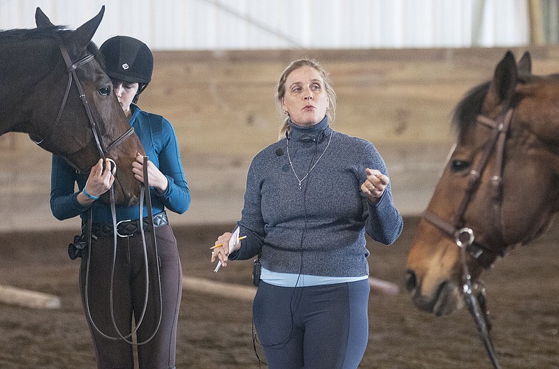 Susie Ouderkirk, newly hired hunter/jumper professor at William Woods University, answers a student's question Wednesday at the end of one of her hour-long classes inside Rowland Applied Riding Arena.