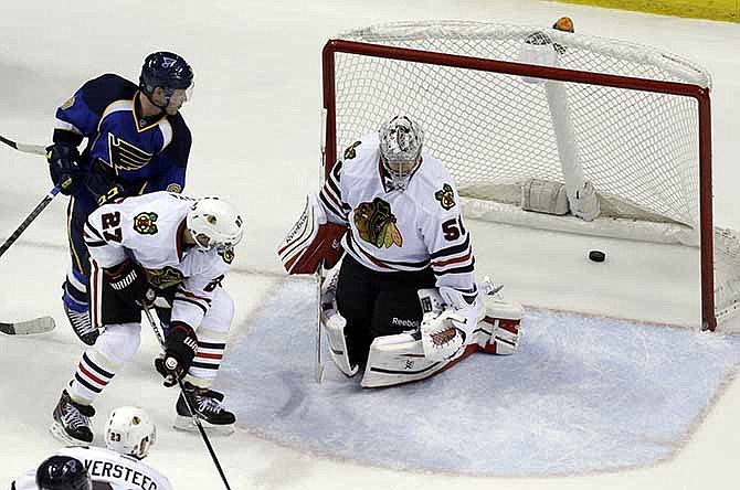 St. Louis Blues' Jaden Schwartz, top left, watches as his shot slips past Chicago Blackhawks goalie Corey Crawford and Johnny Oduya (27), of Sweden, for a goal during the third period in Game 1 of a first-round NHL hockey Stanley Cup playoff series Thursday, April 17, 2014, in St. Louis. The Blues eventually won in triple overtime.
