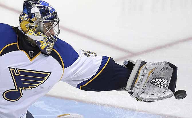 In this April 11, 2014, file photo, St. Louis Blues goalie Ryan Miller reaches for the puck during the third period of an NHL hockey game against the Dallas Stars in Dallas. Miller came to the St. Louis Blues and the goals-against went down until the lineup starting losing bodies. They're hoping to get everybody back sometime the first round of the playoffs, and help make Miller the save machine they traded for again.