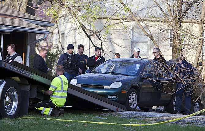 A car is removed by Kansas City police from the house, far right, of a Grandview man suspected in a series of shootings that have occurred on area roadways since early March, according to Police Chief Darryl FortÃ©. He was arrested late Thursday, April 17, 2014, in the 6000 block of East 136th Street of Grandview, Mo., which is just east of Interstate 49 and south of the Three Trails Crossing area where seven shootings happened.