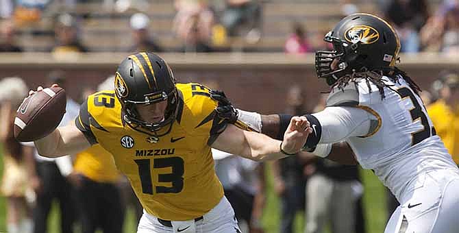 Missouri quarterback Corbin Berkstresser, left, is sacked by Markus Golden, right during the first half of Missouri's Black and Gold spring NCAA college football scrimmage Saturday, April 19, 2014, in Columbia, Mo.