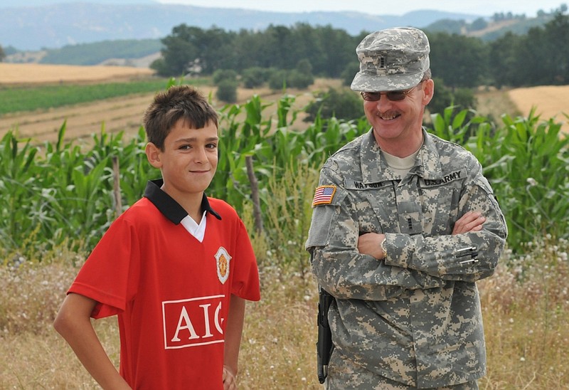 CW4 Randy Watson visits with a Serbian boy while serving as a public affairs officer with a task force in Kosovo in 2008.
