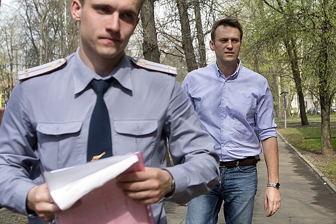 Russian opposition activist and anti-corruption crusader Alexei Navalny, right, is escorted to court by a policeman, left, from his home, where he is currently staying under house arrest in Moscow, Russia. 