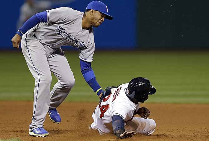 Kansas City Royals shortstop Alcides Escobar, left, tags out Cleveland Indians' Michael Bourn who was attempting to steal second base in the seventh inning of a baseball game on Wednesday, April 23, 2014, in Cleveland.