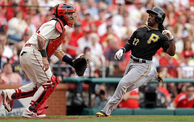 Pittsburgh Pirates' Andrew McCutchen scores on a two-run double by Gaby Sanchez as St. Louis Cardinals catcher Yadier Molina, left, looks for the throw home during the fourth inning of a baseball game Saturday, April 26, 2014, in St. Louis. 