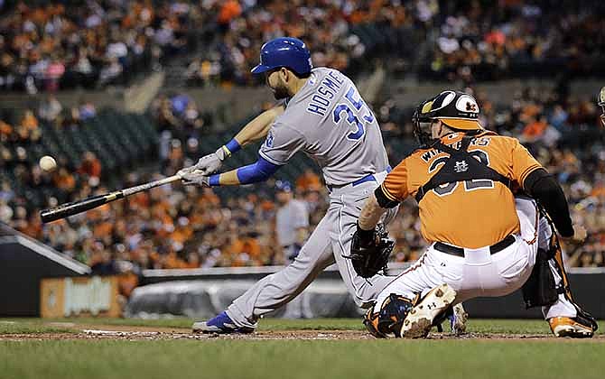 Kansas City Royals' Eric Hosmer doubles in front of Baltimore Orioles catcher Matt Wieters in the third inning of a baseball game, Saturday, April 26, 2014, in Baltimore. Alcides Escobar scored on the play.