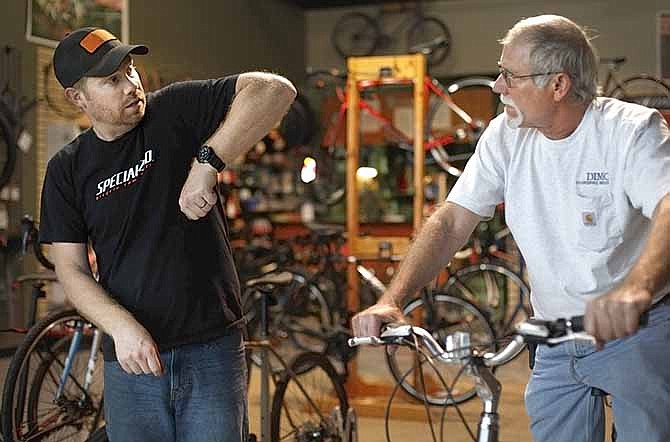 Nick Smith (left) shows a bike to Danny Davis, who stopped by the Red Wheel Bike Shop to purchase a bike for himself and a tandem bicycle trailer for his grandson Thursday afternoon. Smith opened the store in March 2003 and recently began renting bikes.
