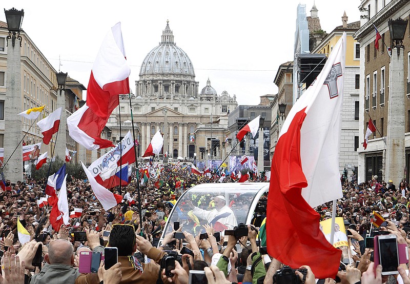 Pope Francis waves to throngs of the faithful from the popemobile during Sunday's canonization ceremonies.
