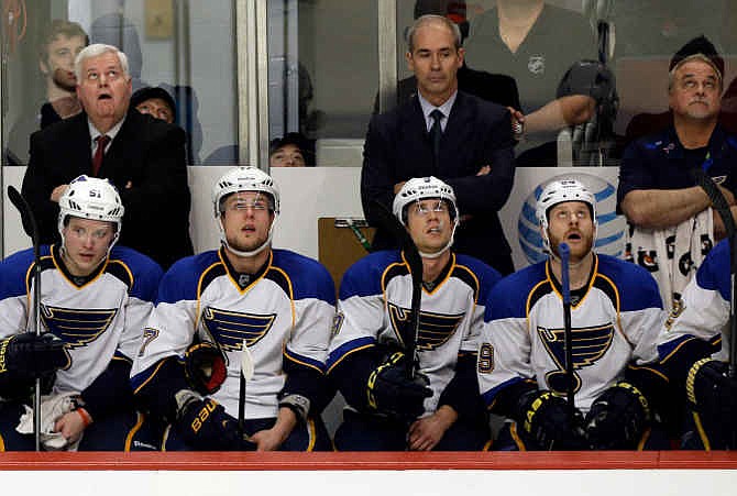 St. Louis Blues head coach Ken Hitchcock, top left, and his players look at the scoreboard after Chicago Blackhawks' Duncan Keith scored during the third period in Game 6 of a first-round NHL hockey playoff series in Chicago, Sunday, April 27, 2014. The Blackhawks won 5-1. 
