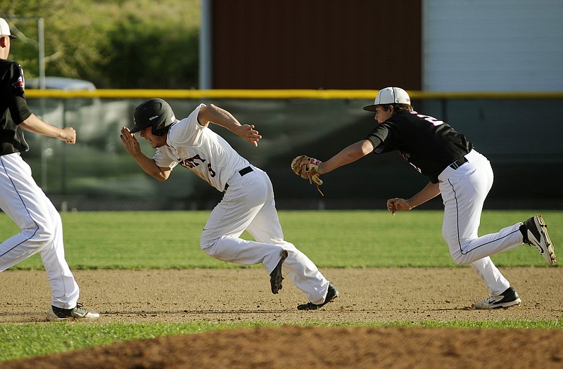 Jefferson City baserunner Alex Johnson sprints toward third as he tries unsuccessfully to escape a rundown as Southern Boone second baseman Gannon Mueller lunges to make the tag during the fifth inning of Monday's game at Vivion Field.