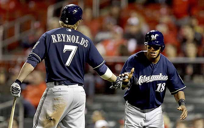 Milwaukee Brewers' Khris Davis, right, is congratulated by teammate Mark Reynolds, left, after scoring on a single by Lyle Overbay during the 11th inning of a baseball game against the St. Louis Cardinals, Tuesday, April 29, 2014, in St. Louis.