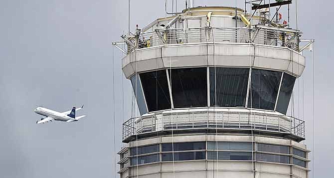 In this March 24, 2011 file photo, a passenger jet flies past the FAA control tower at Washington's Ronald Reagan National Airport.