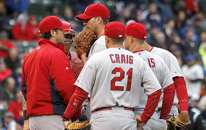 St. Louis Cardinals manager Mike Matheny, left, talks with starting pitcher Adam Wainwright and the complete infield during the fifth inning of a baseball game on Friday, May 2, 2014, in Chicago.