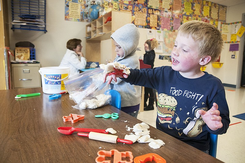 A preschool student at Fulton Education Center plays with Play-Doh on Thursday. The Early Childhood Center screens children before entering the school, and cutting with scissors is included in the test.