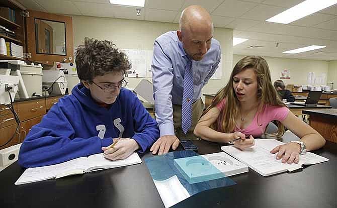 Matthew Davis, left, and Shannon Newerth study the habits of bugs with teacher Chris Kaufman during a Plant and Soil Science class at Beech Grove High School Wednesday, April 30, 2014, in Indianapolis. High school agriculture programs sprouting across the nation's Corn Belt are teaching teenagers, many of them in urban environments, that careers in the field often have nothing to do with cows and plows. 