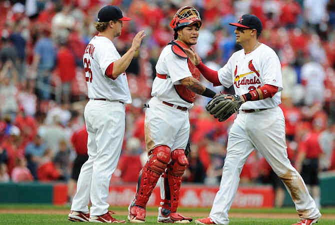 St. Louis Cardinals' Trevor Rosenthal (26), Yadier Molina, center, and Allen Craig, right, celebrate a victory over the Chicago Cubs in a baseball game, Sunday, April 13, 2014, at Busch Stadium in St. Louis. 