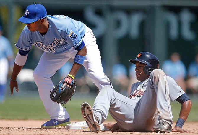 Detroit Tigers' Austin Jackson, right, watches the ball get past Kansas City Royals shortstop Alcides Escobar (2) during the fifth inning of a baseball game at Kauffman Stadium in Kansas City, Mo., Sunday, May 4, 2014. Jackson stole second base on the play. 