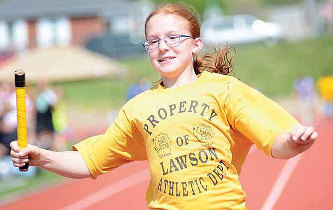 April Werschler, 10, races to hand off the baton to her teammate during the regular relay Saturday at the Little Olympics held at Adkins Stadium in Jefferson City.