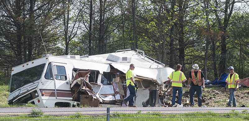 Crews begin to pick up debris from an RV after a truck tanker collided with the vehicle on I-70 Tuesday afternoon.