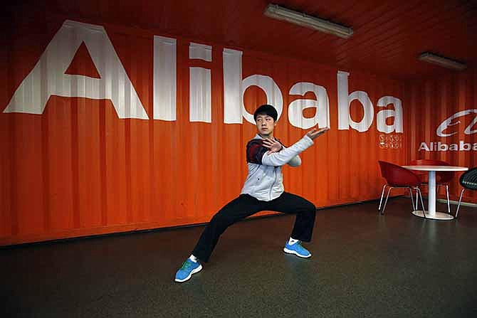 In this file photo taken Tuesday March 26, 2013, a worker performs shadow boxing during an open day at the Alibaba Group office in Hangzhou in east China's Zhejiang province. Alibaba Group is aiming to raise $1 billion in a long-awaited IPO likely to have ripple effects across the Internet. The Tuesday, May 6, 2014 filing sets the stage for the technology industry's biggest initial public offering since short messaging service Twitter and its early investors collected $1.8 billion in its stock market debut last fall. 