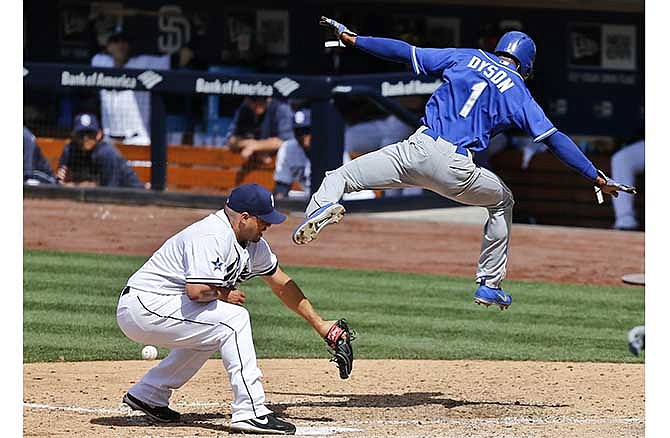 Kansas City Royals' Jarrod Dyson sails through the air while scoring over San Diego Padres pitcher Hector Ambriz after a passed ball during the eighth inning of a baseball game Wednesday, May 7, 2014, in San Diego.