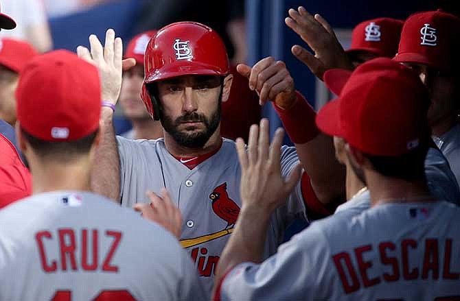 St. Louis Cardinals' Matt Carpenter, center, celebrates a run off a two RBI single by Cardinals' Matt Holliday in the fourth inning of a baseball game against the Atlanta Braves, Wednesday May 7, 2014, in Atlanta.