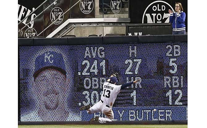 San Diego Padres right fielder Chris Denorfia crashes into the fence and is unable to catch a run producing double by Kansas City Royals' Billy Butler during the 11th inning of a baseball game won 3-1 by the Royals, Tuesday, May 6, 2014, in San Diego.
