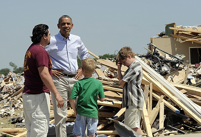 President Barack Obama tours tornado-damaged areas of Vilonia, Ark., on Wednesday, and talks with Daniel Smith and his sons Garrison Dority and Gabriel Dority, right. Obama was visiting with first responders and families affected by the recent tornados before traveling on to California where he will raise money for the Democratic Party and receive an award from a foundation created by movie director Steven Spielberg. 