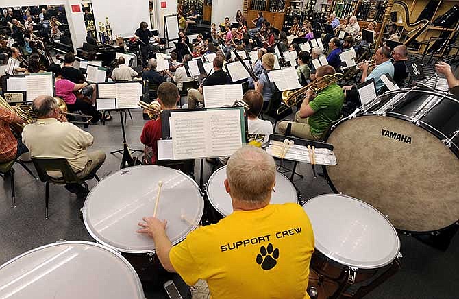 Tom Higgins hits his musical marks on the tympani as he and other members of the Jefferson City Symphony
Orchestra follow Music Director Patrick Clark's lead during a rehearsal at Jefferson City High School on Monday, May 5, 2014.